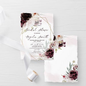 May include: A white invitation with a gold geometric frame and floral design. The text reads "Join us for a Bridal Shower to honour Angela Smith, Saturday, February 20th, 2023, 2:00 - 4:00 pm, The Smith Bistro, 123 Autumn Avenue, Minneapolis, MN 55414, RSVP by January 15th, Target & Amazon, www.amazon.com/weddingregistry/angela-smith".