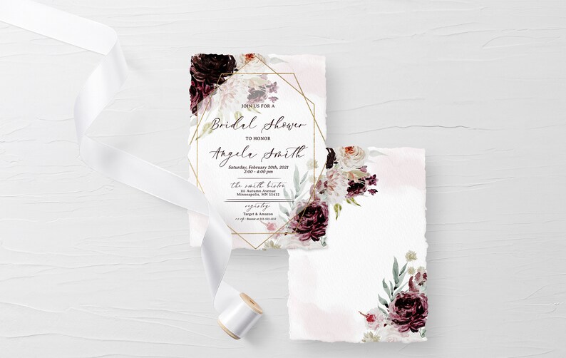 May include: A white invitation with a gold geometric frame and floral design. The text reads "Join us for a Bridal Shower to honour Angela Smith, Saturday, February 20th, 2023, 2:00 - 4:00 pm, The Smith Bistro, 123 Autumn Avenue, Minneapolis, MN 55414, RSVP by January 15th, Target & Amazon, www.amazon.com/weddingregistry/angela-smith".