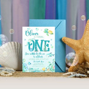Peut inclure: Une carte d'invitation bleue et verte avec une illustration aquarelle d'une tortue, de poissons et d'algues. Le texte sur la carte indique "Oliver a un an. Rejoignez-nous sous l'eau pour f&ecirc;ter &ccedil;a Samedi 25 avril &agrave; 13h00 Chez les Smith 311 Autumn Lane Minneapolis, MN 55432 RSVP avant le 15 avril"