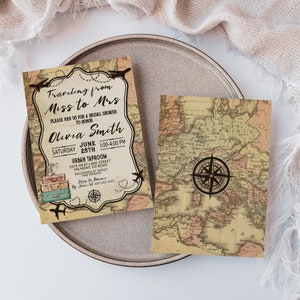 May include: Two vintage-style bridal shower invitations with a map design. One invitation features the text "Traveling from Miss to Mrs" and event details. The other shows a compass rose. The invitations are on a gray plate.