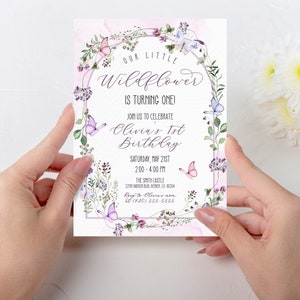 May include: A pink and purple floral birthday invitation with butterflies and the text "Our Little Wildflower is Turning One! Join us to celebrate Olivia's 1st Birthday Saturday, May 21st 2:00 - 4:00 PM The Smith Castle 22181 SOSUR, DEVER, CO 80204 RSVP to Olivia's (720) 555-5555"
