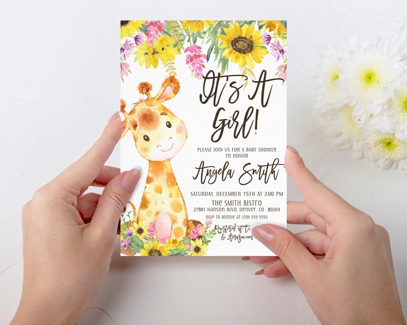 May include: A baby shower invitation with a cute cartoon giraffe illustration. The invitation is decorated with sunflowers and other flowers. The text on the invitation reads "It's a Girl!" and includes the name "Angela Smith", the date and time of the shower, and the location.