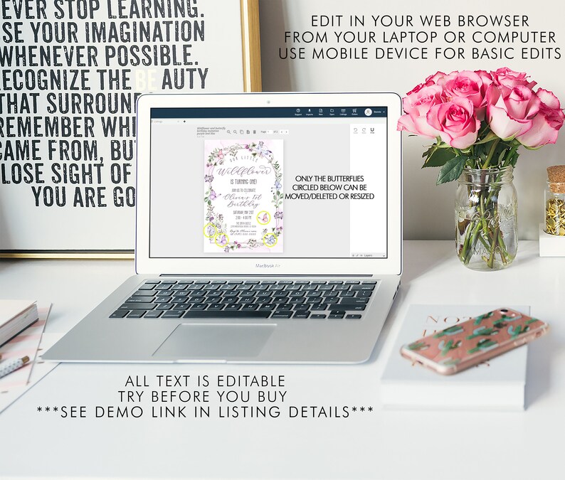 May include: A laptop screen displaying a printable invitation with a floral design and the text "Wildflower is turning one!" and "Oliver's 1st Birthday". The text "Only the butterflies circled below can be moved/deleted or resized" is also visible on the screen. The laptop is on a white desk with a vase of pink roses and a phone with a cactus design.