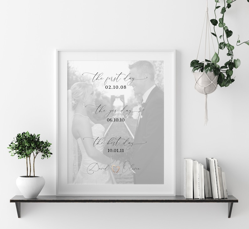 May include: Black and white photo print of a couple on their wedding day. The print features the text "the first day 02.10.08", "the yes day 06.10.10", and "the best day 10.01.11" with the names "David" and "Olivia" at the bottom.