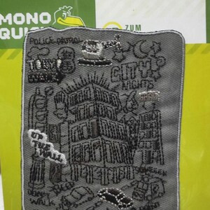 Könnte beinhalten: Ein grauer gestickter Aufnäher mit einer Schwarzweißillustration einer Stadtszene. Der Aufnäher trägt den Text "Up the Wall" und "Police Patrol".