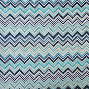 Op de afbeelding: Een blauwe en witte chevron-patroonstof met een subtiele textuur. De stof heeft een herhalend patroon van afwisselende blauwe en witte zigzaglijnen.