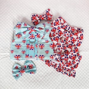 May include: Two dog harnesses featuring a Union Jack design. One harness is light blue with red hearts and the other is white with red hearts. Both harnesses come with a matching bow tie.