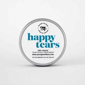 Puede incluir: Una lata de metal plateada con una etiqueta blanca que dice "Groomin' Fur Good" y "happy tears" en texto azul. La etiqueta también incluye el texto "PRO-GRADE TEAR STAIN TREATMENT" y "www.youngwoofians.com". La parte inferior de la etiqueta dice "*NOT RECOMMENDED FOR LONG TERM USE".