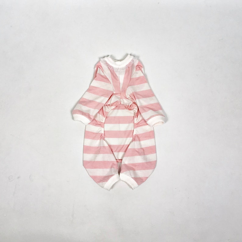 The flatlay of the Pink & White Striped onesie shows white cuffs on the hems and a frill around the neckline.