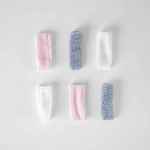 以下が含まれることがあります： ピンク、白、青の3色でできた小さなタオルが6枚。タオルは折り畳まれ、3枚ずつ2列に並んでいます。