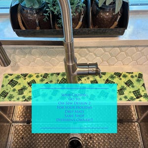 May include: A rectangular fabric drip mat featuring a green pattern of leprechaun hats and shamrocks, positioned around a stainless steel kitchen faucet. The mat includes text stating: SHOP CLOSING GO TO OH SEW DESIGN 2 FOR YOUR HOLIDAY DRIP MATS.