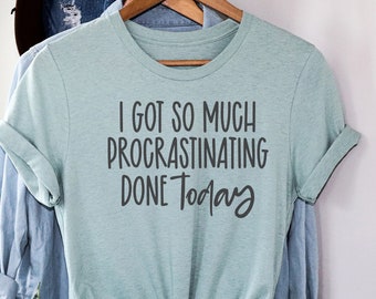 May include: A light blue t-shirt with the text "I got so much procrastinating done today" in black lettering.