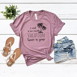 Puede incluir: Una camiseta color malva con un estampado gr&aacute;fico de palmeras y el texto "Necesito seis meses de vacaciones dos veces al a&ntilde;o".
