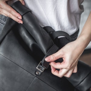 May include: A black leather backpack with a buckle closure.