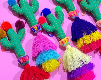 May include: Five green felt cactus ornaments with colorful pom-poms and multi-colored tassel accents.