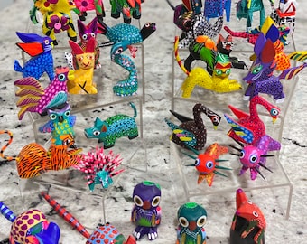 Pode incluir: Uma coleção de figuras de animais de madeira pintadas à mão e coloridas. As figuras são organizadas em prateleiras e incluem uma variedade de animais, como pássaros, gatos, cães e insetos.