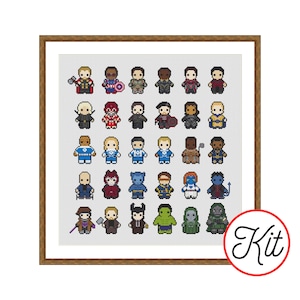 May include: A cross-stitch pattern featuring a grid of thirty pixel-art style superhero characters in various colorful costumes, arranged in five rows of six, framed in a brown wooden border with a circular red and white Kit logo in the corner.