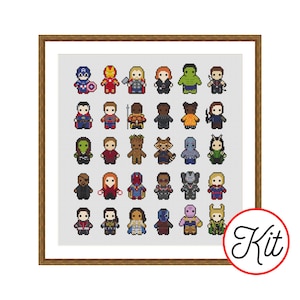 May include: A cross stitch pattern featuring a grid of thirty pixel-art style superhero characters in various colours, arranged in five rows of six. The design is enclosed in a brown frame, and a circular white badge with the word Kit is in the corner.