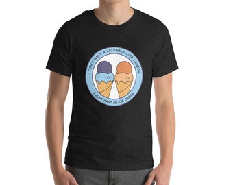 May include: A dark heather grey t-shirt with a graphic of two ice cream cones. The text on the shirt reads "I don't want a valuable life lesson, I just want an ice cream."