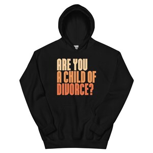 Puede incluir: Sudadera con capucha negra con el texto "ARE YOU A CHILD OF DIVORCE?" en un degradado de naranja y amarillo. La sudadera con capucha tiene un cordón y un bolsillo delantero. La sudadera está hecha de un material suave.