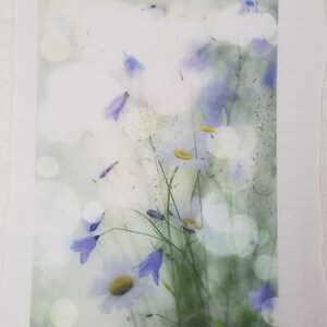 May include: A watercolor painting of a bouquet of white and purple flowers with a blurred background. The flowers are arranged in a vase and are surrounded by green leaves.