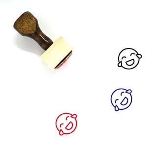May include: A wooden rubber stamp with a handle and a red ink pad. The stamp features a black and white line drawing of a cartoon face with tears of joy.