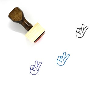 May include: Wooden stamp with a peace sign design. The stamp is brown with a red ink pad. The peace sign is outlined in blue.