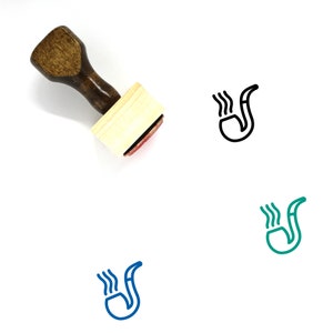 Könnte beinhalten: Ein Holz-Stempel mit braunem Griff und einem rechteckigen Holzblock. Der Stempel zeigt eine schwarze Strichzeichnung einer rauchenden Pfeife.