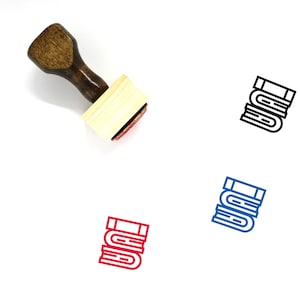 May include: A wooden rubber stamp with a handle and a rectangular base. The base has a red ink pad and a design of three stacked books. The design is also shown in black, blue, and red.