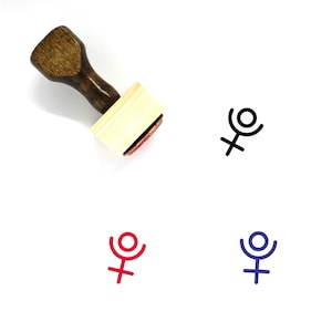 May include: A wooden stamp with a dark brown handle and a light-colored rectangular stamp base. The stamp is pressed onto a white surface, leaving impressions of a symbol in black, red, and blue.