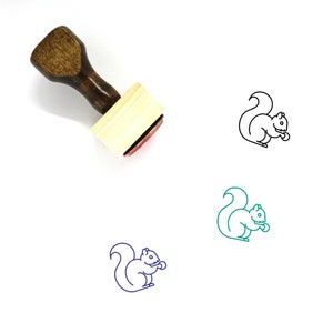 May include: A wooden rubber stamp with a brown handle and a rectangular base. The stamp features a line drawing of a squirrel holding a nut.