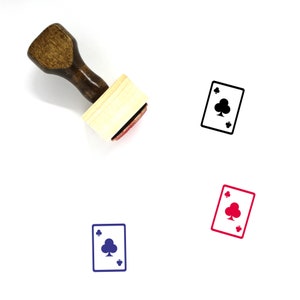 Puede incluir: Un sello de goma de madera con un mango marrón y una base rectangular de madera. El sello presenta un contorno negro de una carta de juego con un símbolo de trébol.