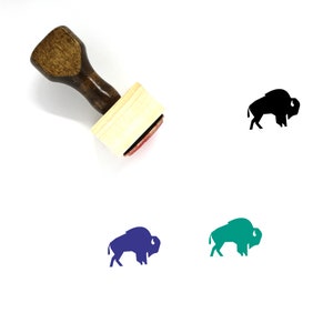 May include: A wooden stamp with a bison design. The stamp has a light wood block and a dark brown handle. There are three additional bison designs in black, blue, and teal.