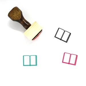 以下が含まれることがあります： ハンドルと長方形のベースが付いた木製スタンプ。スタンプには、背表紙のある開いた本の黒いアウトラインが描かれています。画像には、黒、緑、赤の3色でスタンプが表示されています。