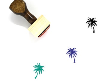 May include: A wooden rubber stamp with a palm tree design. The stamp is on a white background. The palm tree is shown in black, green, and blue.