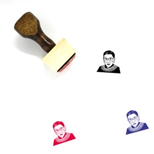 Könnte beinhalten: Ein Holz-Stempel mit einem Schwarzweißbild von Ruth Bader Ginsburg. Der Stempel befindet sich auf einer weißen Oberfläche. Unter dem Stempel befinden sich drei verschiedene farbige Versionen des Bildes.