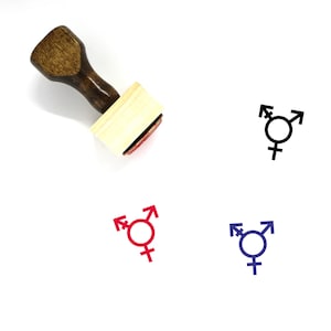 Puede incluir: Un sello de goma de madera con mango y base rectangular. El sello presenta un símbolo transgénero en negro, rojo y azul.