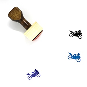 May include: A wooden rubber stamp with a black and white image of a motorcycle. The stamp is on a white background.