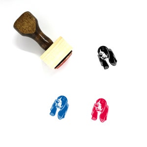 May include: A wooden rubber stamp with a black and white illustration of a Bloodhound dog's head. The stamp is on a white background. There are three other images of the dog's head in different colors: black, blue, and red.