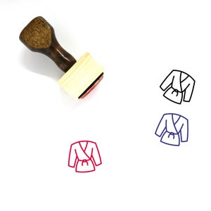 May include: A wooden rubber stamp with a handle and a rectangular base. The stamp features a line drawing of a robe with a belt. The image is shown in black, blue, and red.
