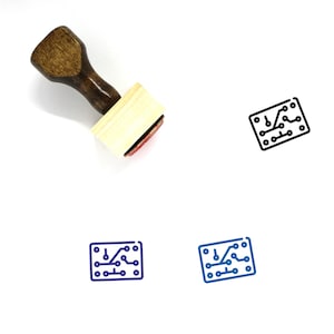 May include: A wooden rubber stamp with a handle and a rectangular red ink pad. The stamp features a black line drawing of a circuit board with a diagonal line.