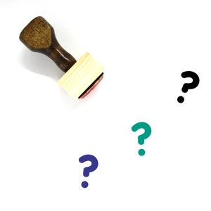 May include: A wooden rubber stamp with a question mark design. The stamp is on a white surface with three question marks in different colours: black, teal, and blue.