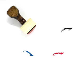 May include: A wooden stamp with a handle and a rectangular ink pad. The ink pad is red and has a black outline of the island of Cuba. There are three impressions of the island of Cuba in black, blue, and red ink on a white background.