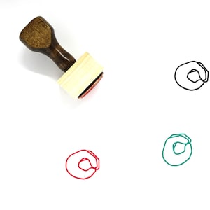 May include: A wooden stamp with a handle and a rectangular base. The stamp is inked with red ink and shows a simple outline of a doughnut. The image also shows three different coloured outlines of the doughnut in black, green, and red.