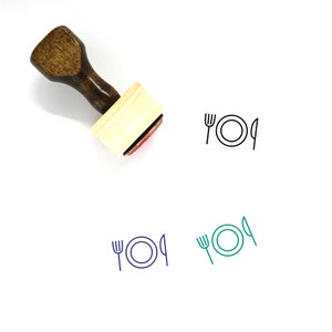 May include: A wooden handled stamp with a rectangular base. The stamp's red ink pad shows a plate, fork, and knife design. Below are three additional illustrations of the same design in black, blue, and teal.