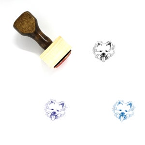 May include: A wooden rubber stamp with a black and white illustration of a Pomeranian dog's head. The stamp is on a white background. The dog is shown with its tongue sticking out.