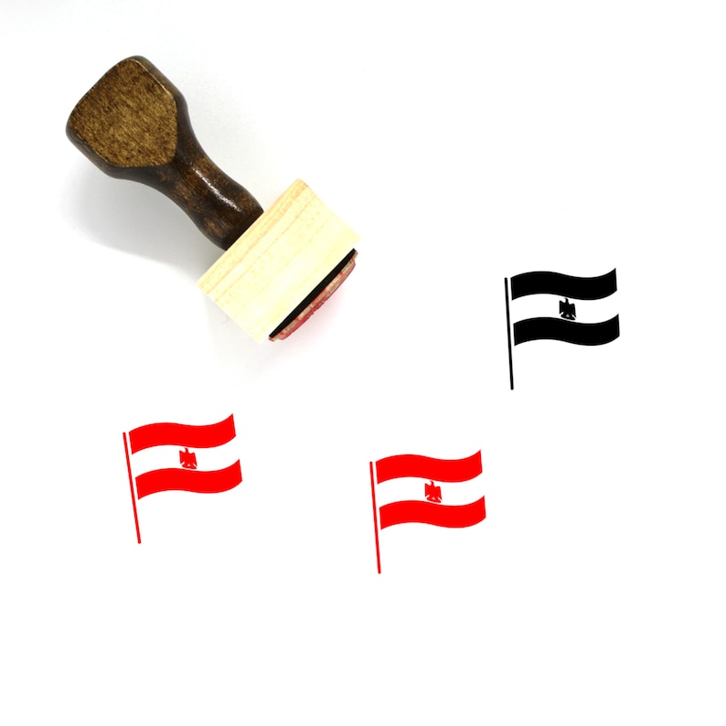 Puede incluir: Un sello de goma de madera con una almohadilla de tinta roja. El sello presenta una imagen en blanco y negro de una bandera con un &aacute;guila estilizada. La bandera ondea al viento. Hay otras dos im&aacute;genes de la bandera en rojo y blanco.