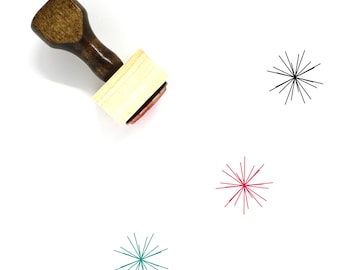 May include: A wooden stamp with a handle and a square base. The stamp has a red ink pad and a design of a starburst with radiating lines. Three starburst designs are shown in black, red, and teal.