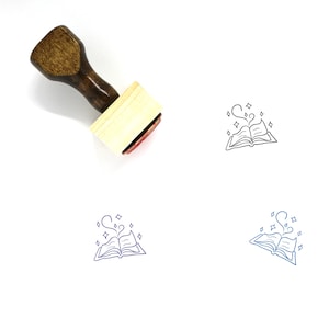 May include: A wooden stamp with a brown handle and a light-colored rectangular base. The stamp's imprint features an open book with magical elements, including a heart-shaped wisp and sparkling stars. Several book imprints are shown in black and blue.