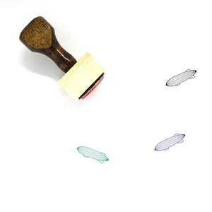 May include: A wooden rubber stamp with a red ink pad. The stamp features a black line drawing of an airship or blimp.